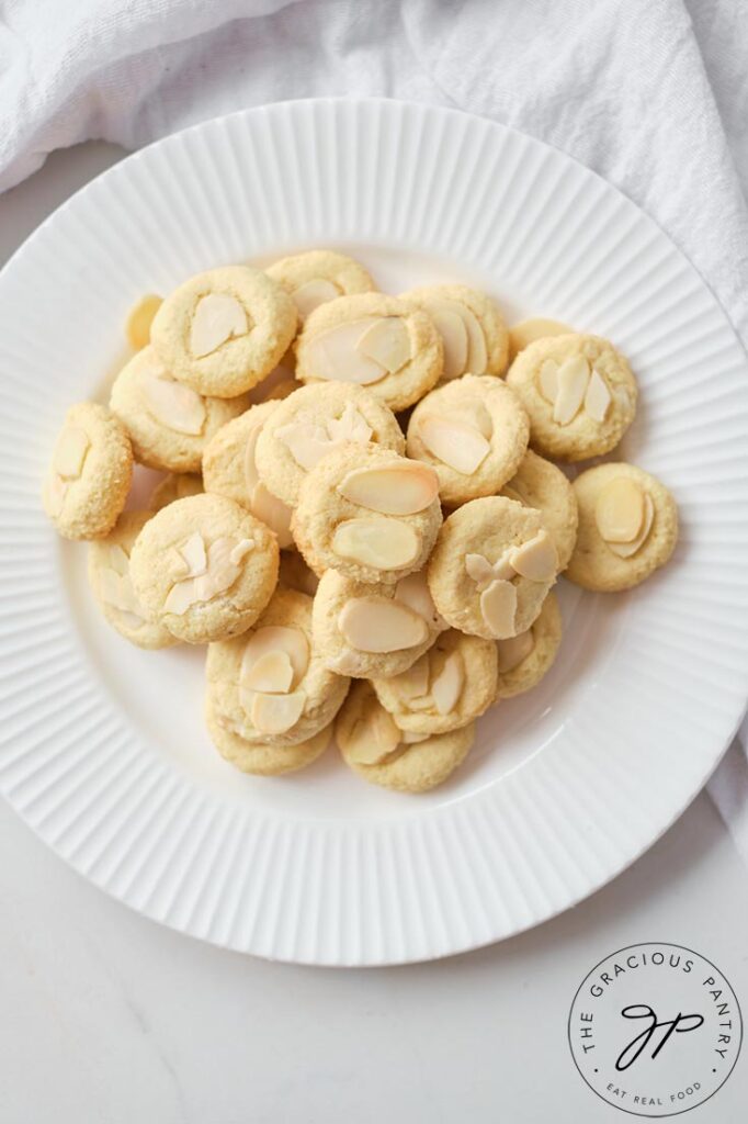 An overhead view looking down onto a white plate filled with these Almond Cookies.