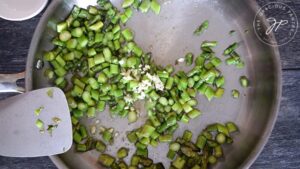 Adding garlic to the skillet.