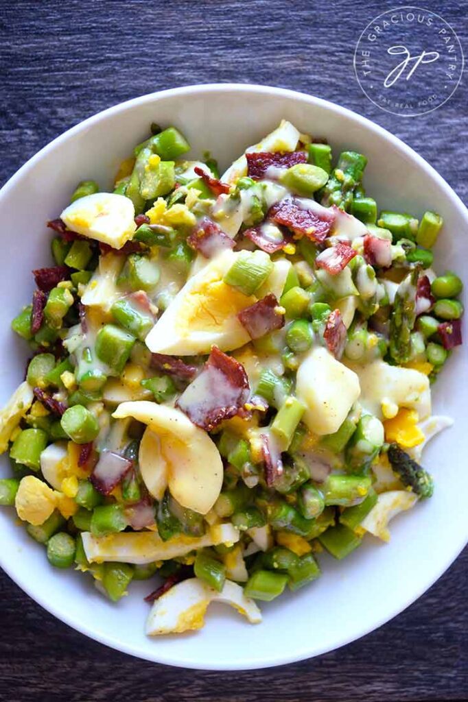 An overhead view of this Asparagus Salad in a white bowl.