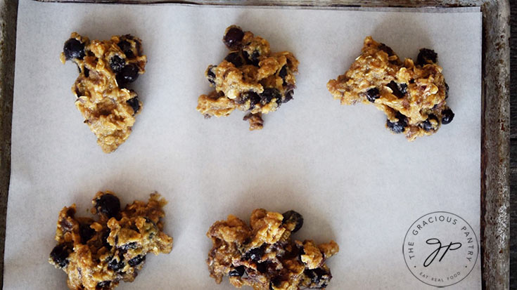 The cookie batter spooned onto a parchment lined cookie sheet.