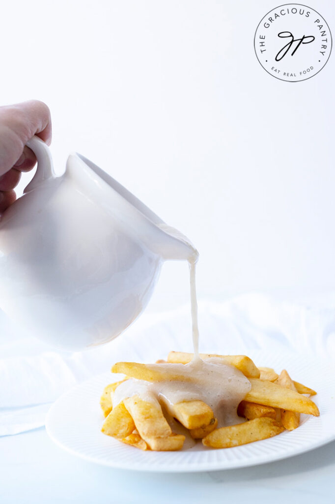 Chicken Broth Gravy being poured over french fries.