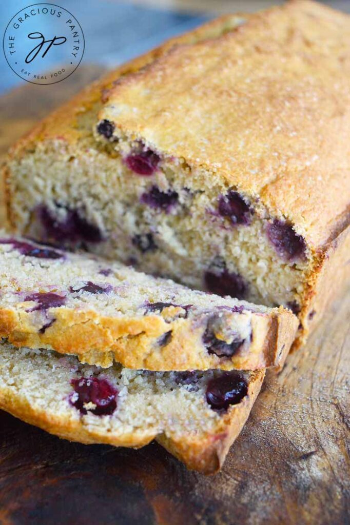 A side view of a loaf of Lemon Blueberry Bread with two slices cut at the front of the loaf.