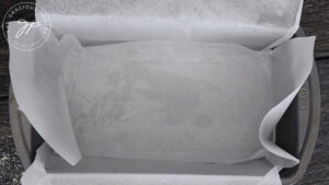 A loaf pan, lined with parchment and sprayed with oil.