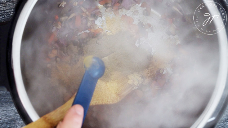 Adding the spices to the sautéd vegetables.