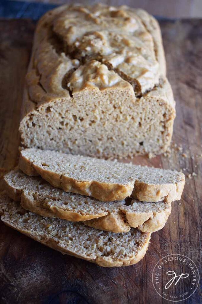 A loaf of Peanut Butter Bread with three slices sliced off one end, sitting on a cutting board.