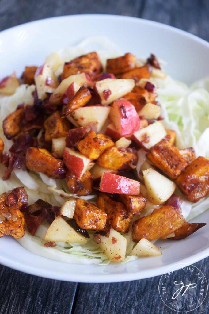 And up close view of this served Roasted Potato Salad on a bed of cabbage in a white bowl.