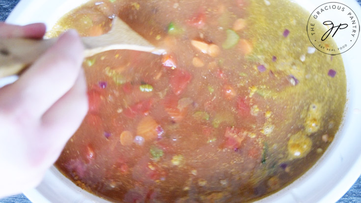 Stirring the ingredients in the slow cooker to make this Slow Cooker Curry Lentil Soup Recipe