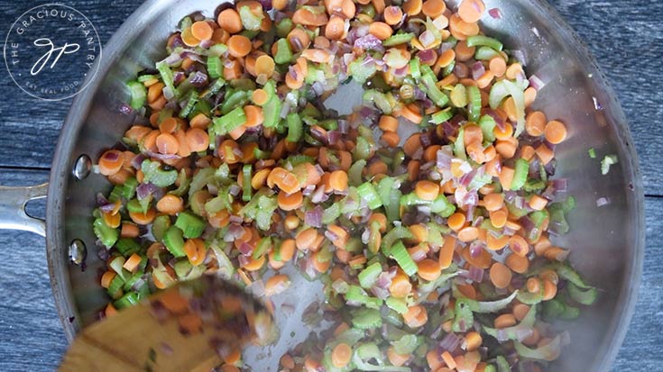 Cooking the vegetables until the onions are translucent.