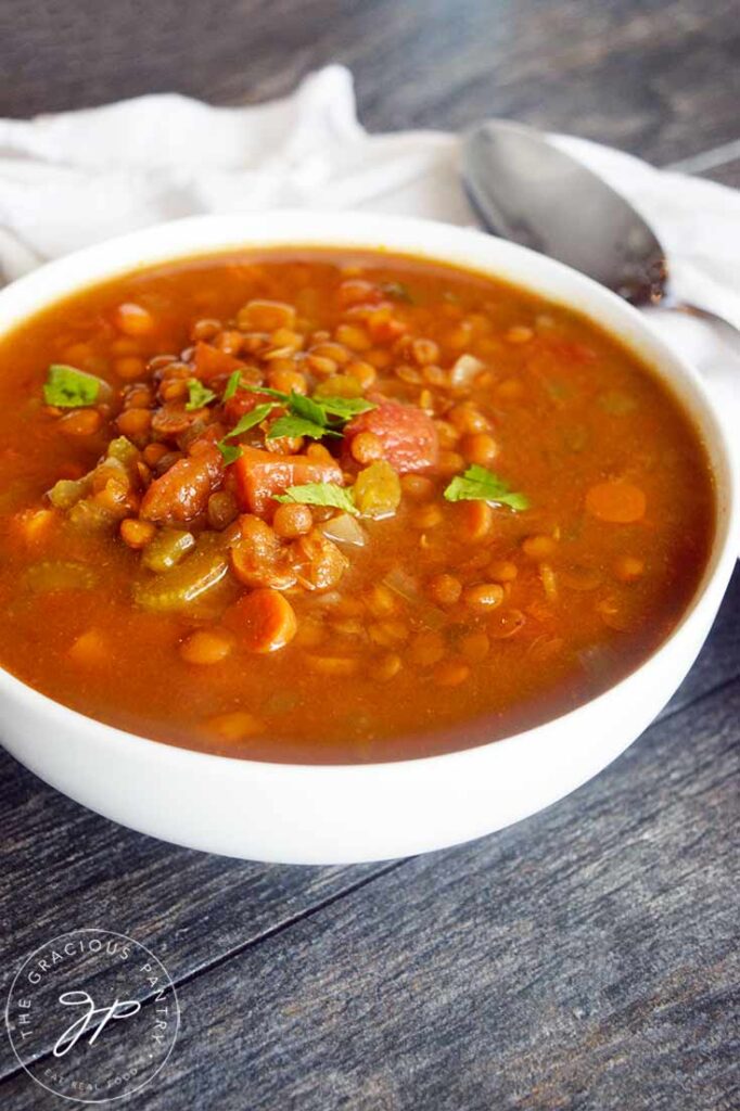 A front view of a white bowl filled with this Slow Cooker Curry Lentil Soup.