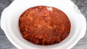 The salsa and diced tomatoes layered over the chicken in the crock.
