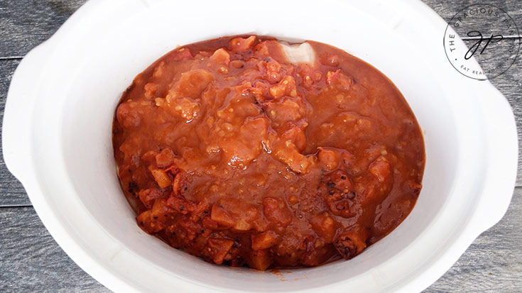 The salsa and diced tomatoes layered over the chicken in the crock.