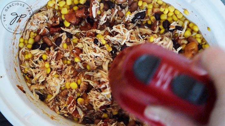 Shredding the Slow Cooker Southwestern Chicken with an electric mixer.