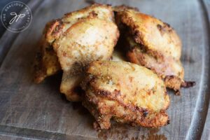 The finished Tuscan Chicken Thighs sitting on a cutting board.