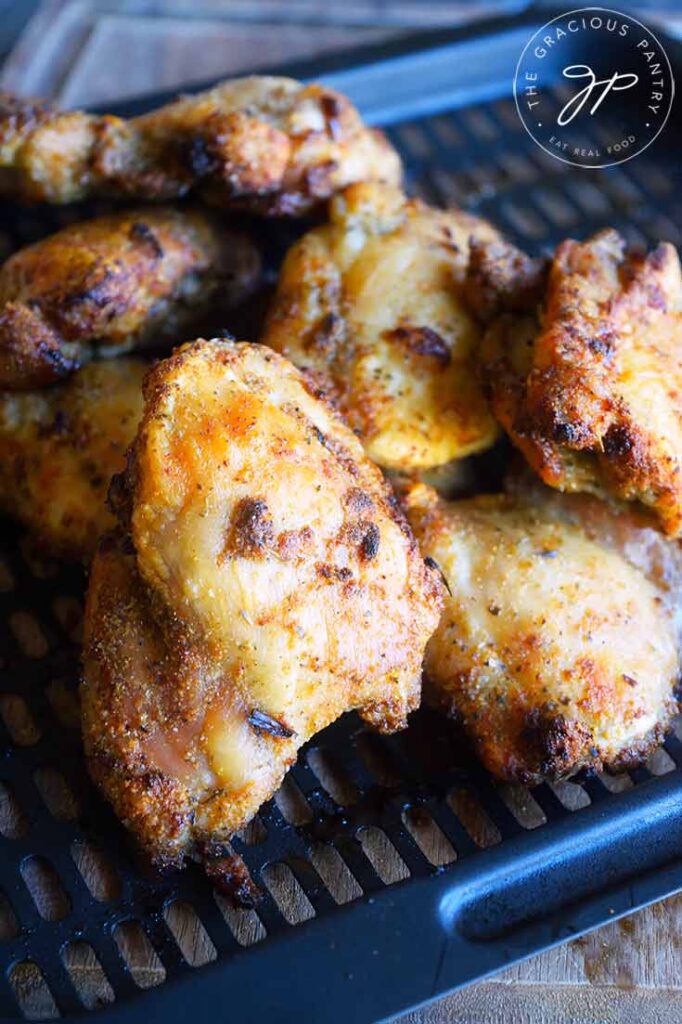 Tuscan Chicken Thighs just out of the air fryers, piled up on the air fryer tray.