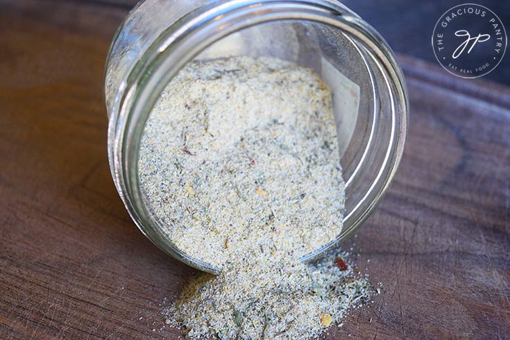 A side view of the finished Tuscan Seasoning Recipe in a tipped over jar.