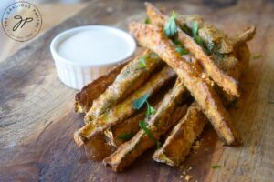 The finishedCajun Zucchini Sticks on a cutting board in a pile.