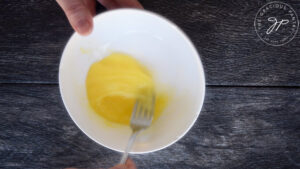 Whisking the eggs for battering these Cajun Zucchini Sticks.