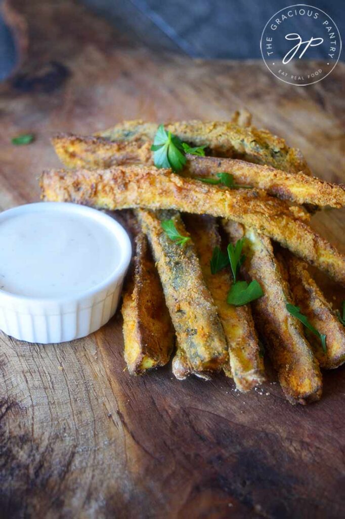 A side view of these Cajun Zucchini Sticks on a cutting board.