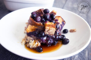 The finished Blueberry French Toast Casserole and a portion served on a plate.