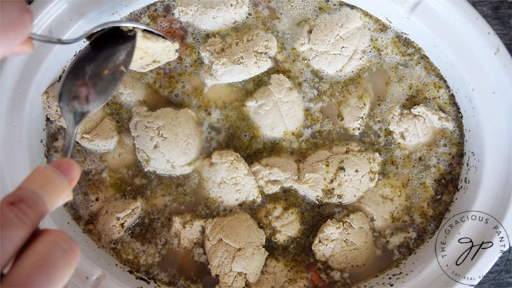 Spooning the dumplings into the hot broth.