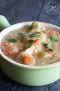 A side view of this Healthy Chicken And Dumplings in a green crock, ready to eat.