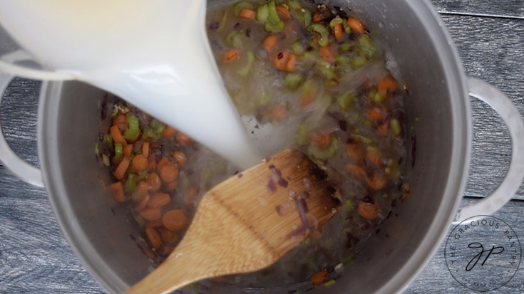 Adding the broth to the pot.