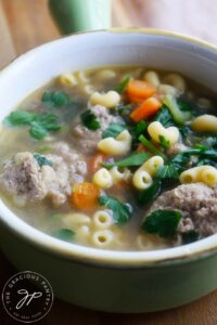A side view of this Healthy Italian Wedding Soup in a green crock.
