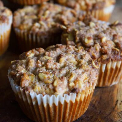 A side view of a group of Oat Flour Muffins With Streusel Topping on a cutting board.