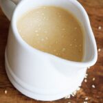 A white, small pitcher filled with this Sesame Vinaigrette.