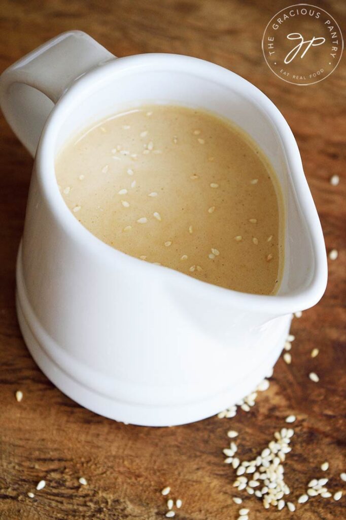 A white, small pitcher filled with this Sesame Vinaigrette.