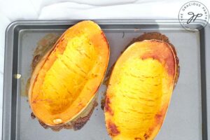 The roasted spaghetti squash, golden brown from baking, sitting on a baking sheet.