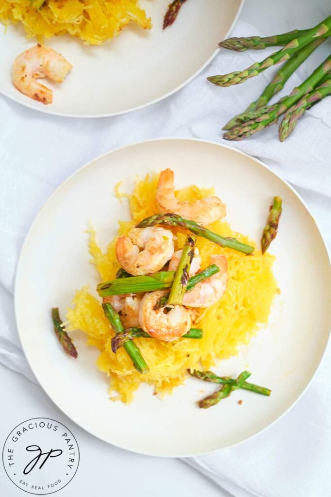 An overhead view of this Shrimp And Asparagus Spaghetti Squash Spaghetti on a white, round plate.