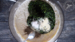 Adding the spinach and spices to the food processor for this Healthy Spinach Artichoke Dip Recipe