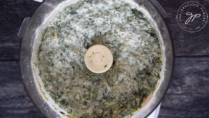 The spinach blended into the Healthy Spinach Artichoke Dip and sitting in the food processor.