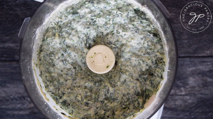 The spinach blended into the Healthy Spinach Artichoke Dip and sitting in the food processor.