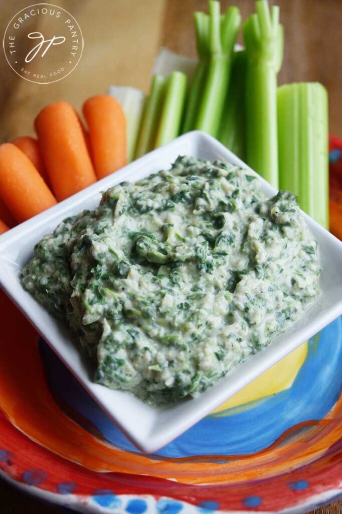 An up close view of a square white dish filled with this Healthy Spinach Artichoke Dip Recipe