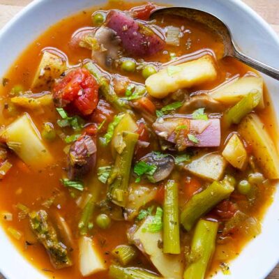 An overhead view looking down into a white bowl filled with this Spring Minestrone Soup Recipe