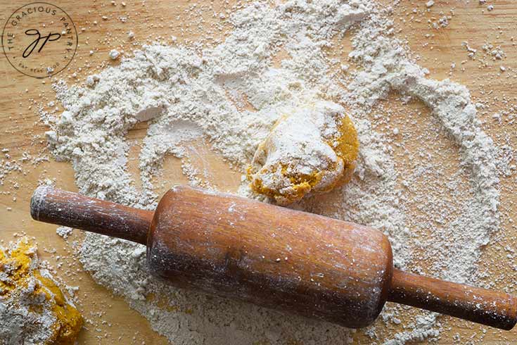 A portion of dough on a floured surface, read to be rolled out to make this Sweet Potato Flatbread.