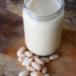 A side view of a glass jar filled with this White Bean Alfredo Sauce.