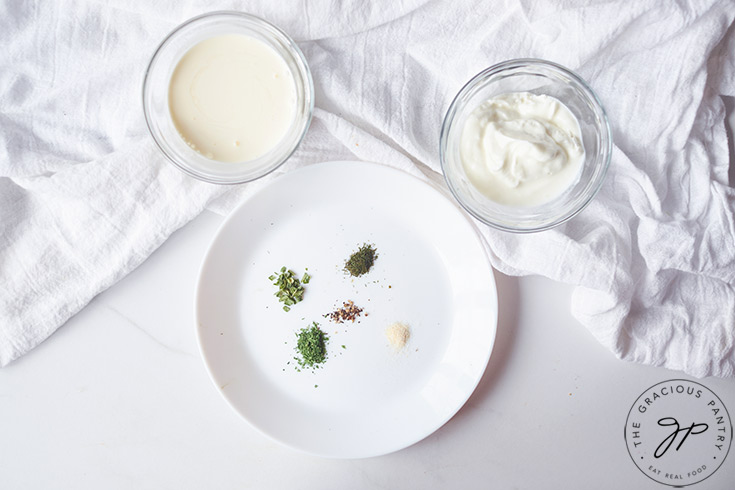 The individual ingredients for this Buttermilk Ranch Dressing Recipe in separate bowls and plates.