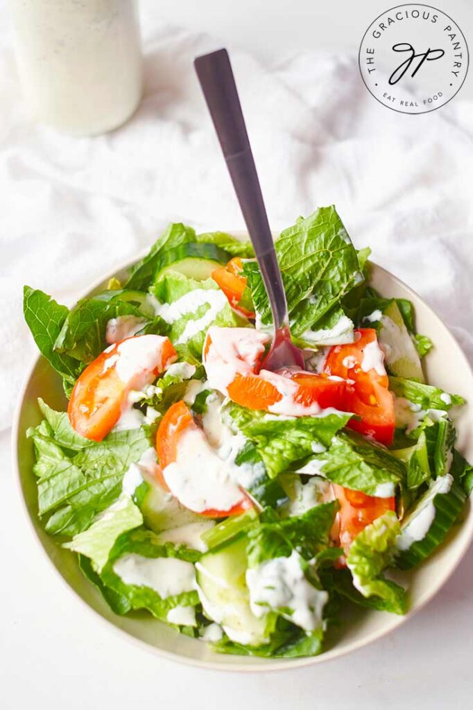 An overhead shot of the green salad with ranch dressing on top.