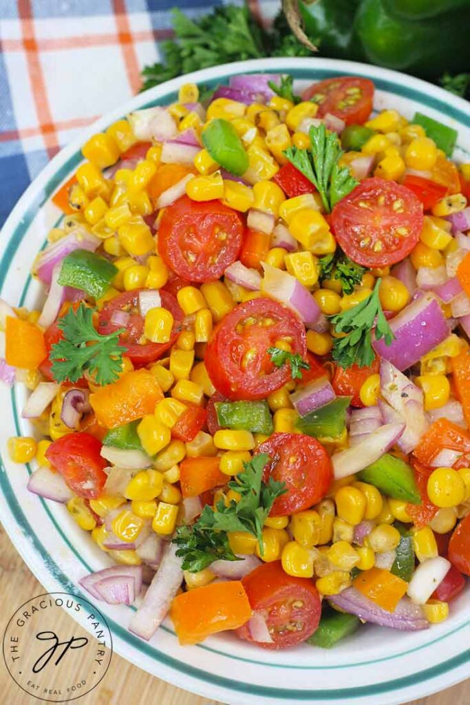 A side view of this Cajun Corn Salad Recipe in a bowl on a table.