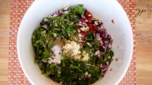 The ingredients for this Chickpea Salad Recipe sitting in a white mixing bowl, waiting to be tossed together to finish the salad.