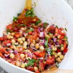 A side view of a white mixing bowl filled with this Chickpea Salad Recipe.