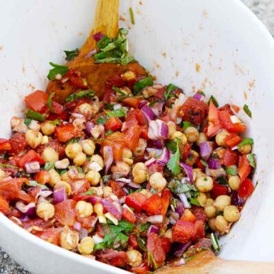 A side view of a white mixing bowl filled with this Chickpea Salad Recipe.