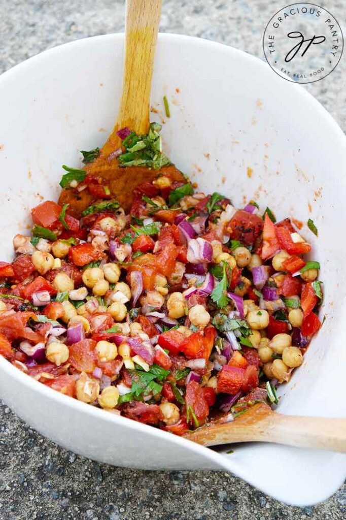 A side view of a white mixing bowl filled with this Chickpea Salad Recipe.