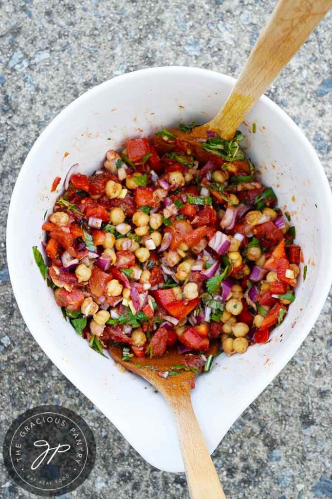 An overhead view looking down into a white mixing bowl filled with this Chickpea Salad Recipe.