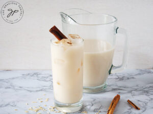 The finished, homemade horchata served in a glass and garnished with a cinnamon stick.