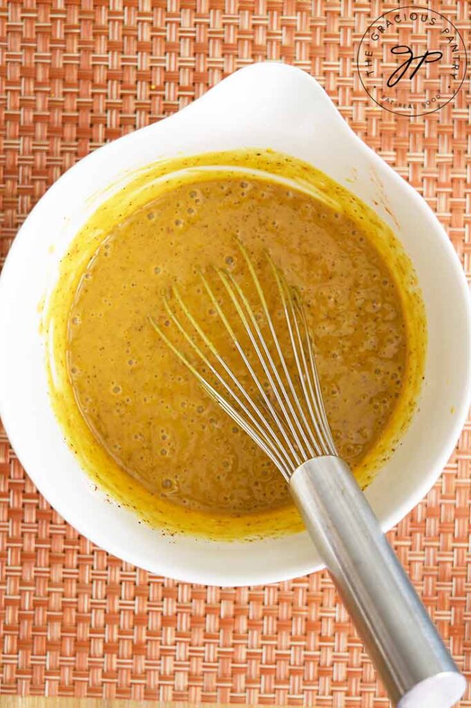 The just whisked Carolina Mustard Barbecue Sauce in a white mixing bowl.