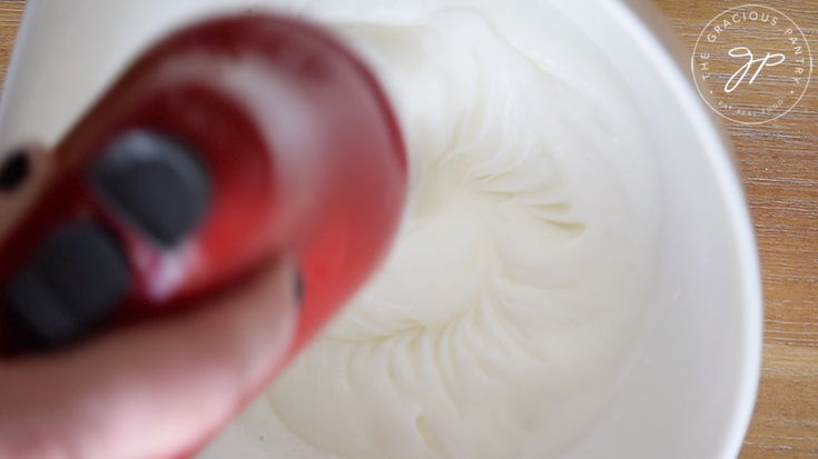 Beating the egg whites with an electric mixer.